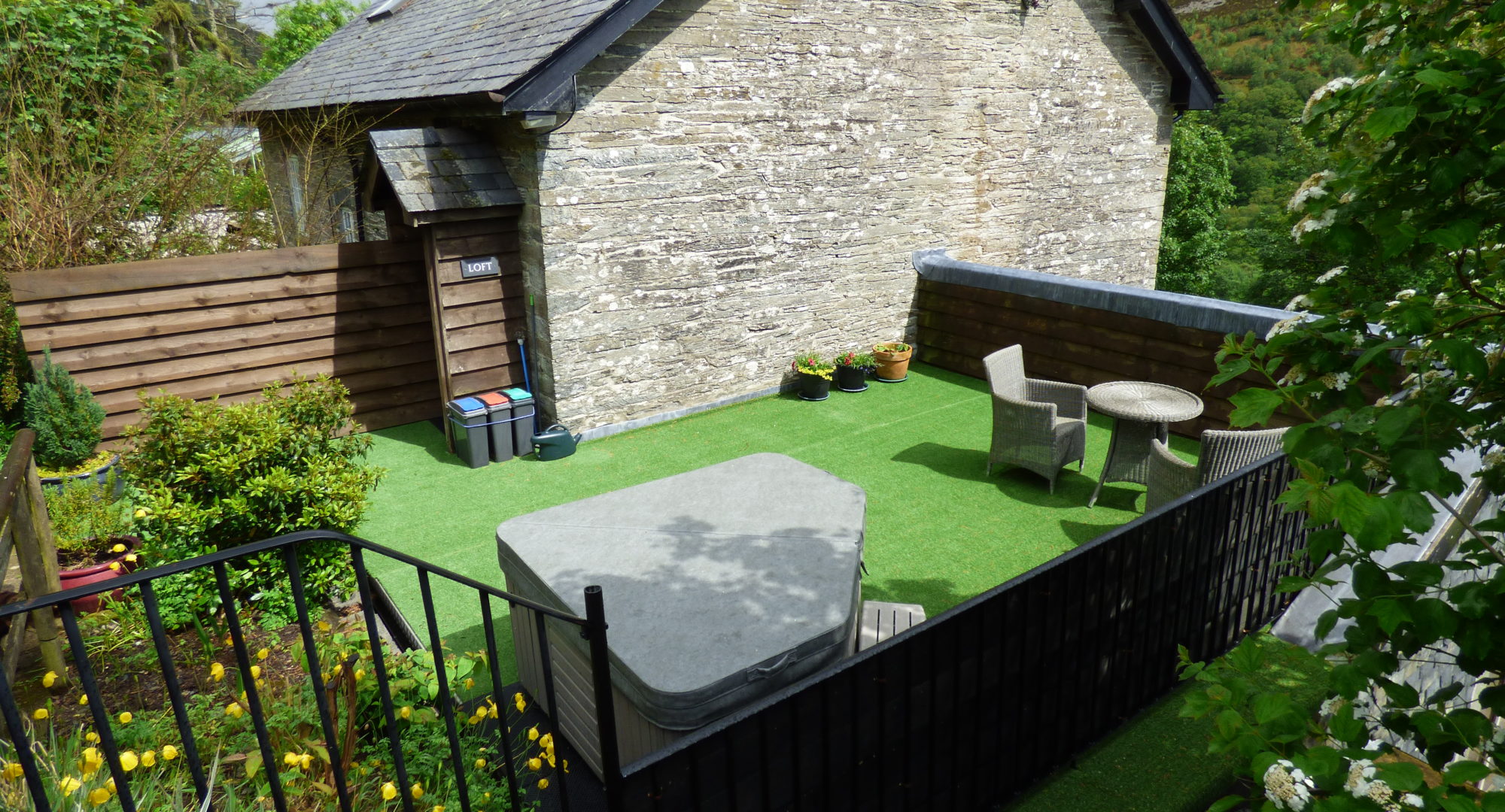 The garden of the couples cottage with a hot tub covered over